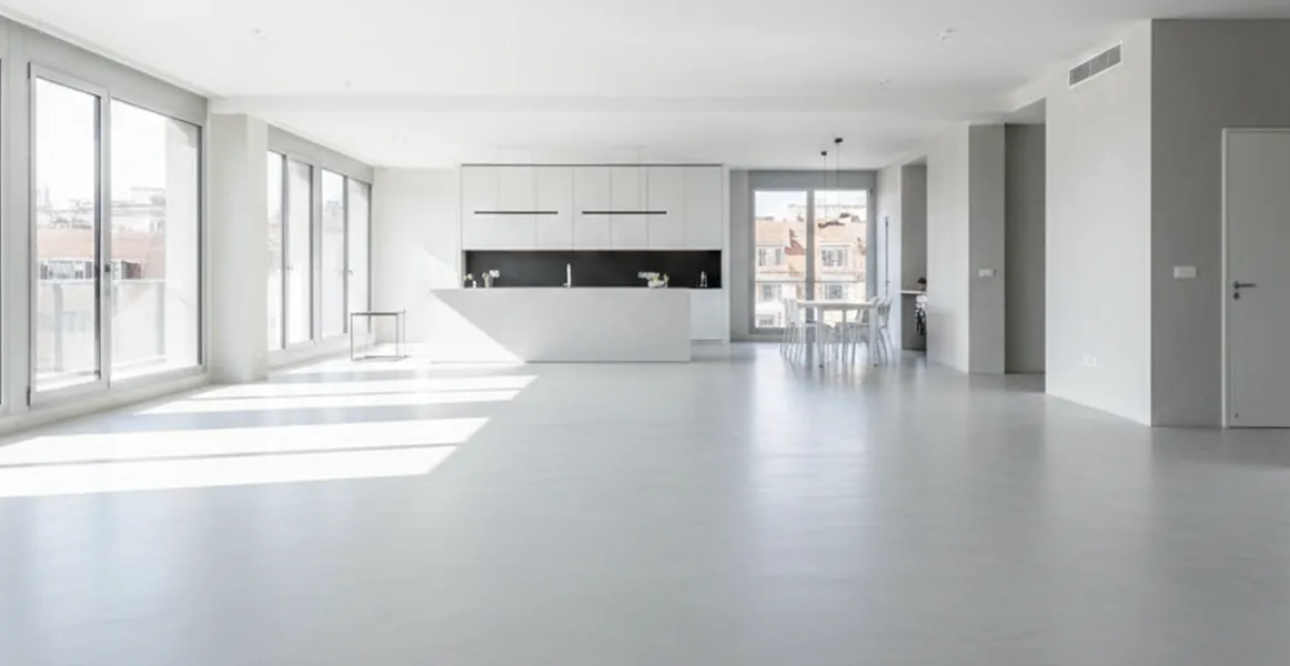 Aplicación de microcemento decorativo en suelos de grandes superficies, acabado continuo sin juntas en color gris claro satinado